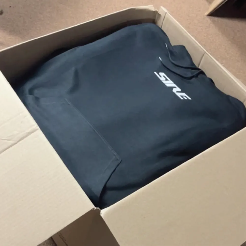 Navy custom hoodie with printed chest logo packed in a box